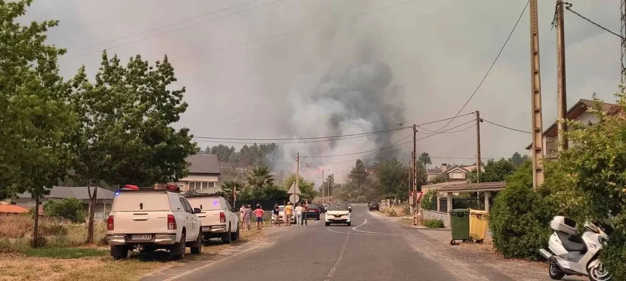 Efectivos antiincendios e veci&ntilde;os vendo o avance das lapas. | FOTO:  Xos&eacute; Lois Colmenero.