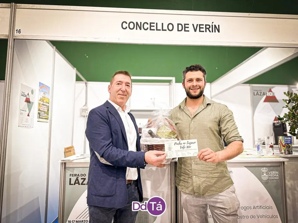 Manuel Lorenzo entrega a Alejandro P&eacute;rez el vale de 100 euros. Fue el ganador del sorteo "Pincha no L&aacute;zaro". | FOTO: Anabel G. Sim&oacute;n.