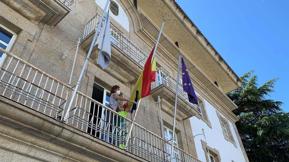 Rosario Rodríguez, la segunda teniente de alcalde, coloca el crespón negro en la bandera de España. | FOTO: María D.