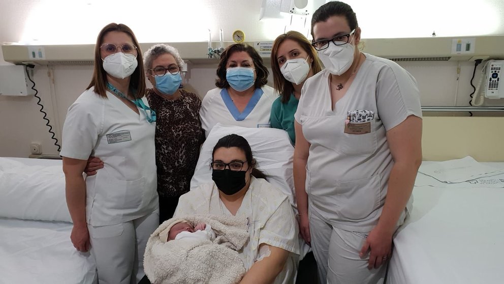 Madre e hija con parte del equipo médico que asistió al parto y un familiar.