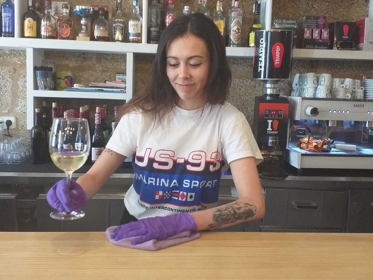 Claudia Veiga, camarera do Bar Plaza, servindo con guantes para previr o foco. | FOTO: Xosé Lois Colmenero.