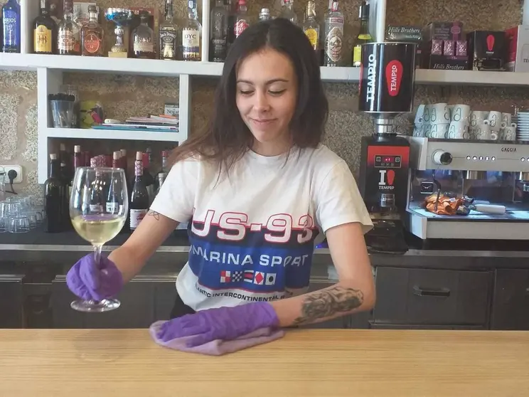 Claudia Veiga, camarera do Bar Plaza, servindo con guantes para previr o foco. | FOTO: Xos&eacute; Lois Colmenero.