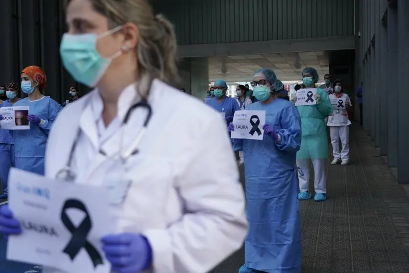 Sanitarios desplegados con carteles en recuerdo de Laura, la sanitaria fallecida contagiada de Covid-19 que trabajaba en Gestlab (Grupo IMQ), prestando su labor en la Cl&iacute;nica Zorrotzaurre. | FOTO: H. Bilbao/EP