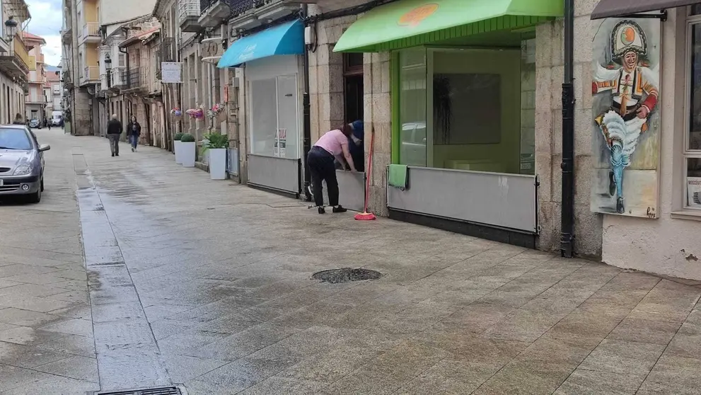 Vecinos y comerciantes de la calle Mayor se preparan para una pr&oacute;xima tromba. | FOTO: Xos&eacute; Lois Colmenero.
