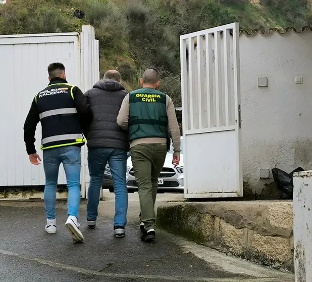 Un agente de la Polic&iacute;a Nacional y otro de la Guardia Civil, con el detenido, en el cuartel verinense. | FOTO: Guardia Civil.