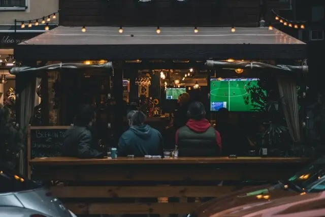 aficionados viendo un partido de f&uacute;tbol en un bar - yasin-alsbey-PE6A-Iytkks-unsplash