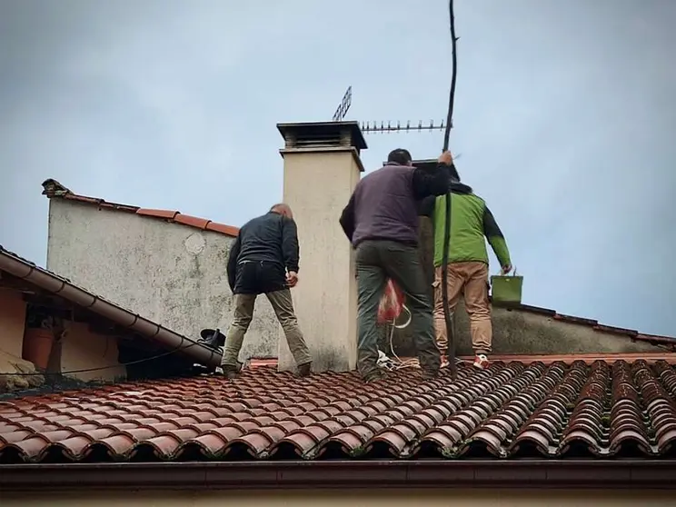 Vecinos de Vilamaior, en Ver&iacute;n, en lo alto de un tejado, colaborando en el rescate de Rayo.
