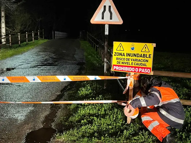 Una voluntaria de Protecci&oacute;n Civil precinta los accesos al puente de A Pousa.