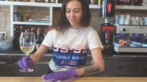 Claudia Veiga, camarera do Bar Plaza, servindo con guantes para previr o foco. | FOTO: Xos&eacute; Lois Colmenero.