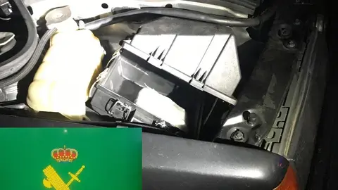 El alijo estaba oculto en el recept&aacute;culo del filtro del aire del motor del Mercedes. | FOTO: Guardia Civil.