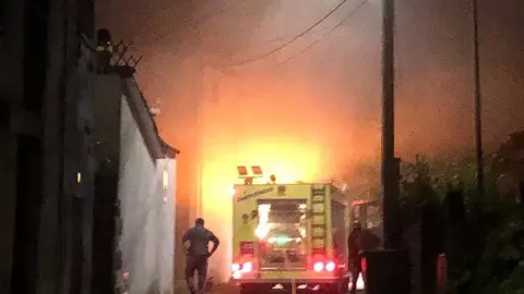 Os efectivos do GES de Laza, tentando conter o lume na vivenda da r&uacute;a Barrio.
