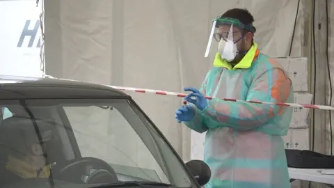 Un sanitario entrega un tubo de muestras a uno de los verinenses que acudieron a la cita. | FOTO: Iv&aacute;n Iglesias.