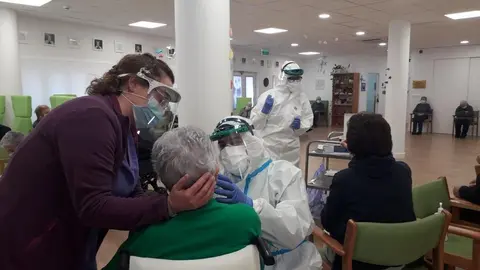 Nieves Justo, &aacute; esquerda, axuda ao equipo do Sergas a realizar un exudado a unha das usuarias do centro de d&iacute;a.
