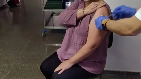 Chelo Ferreiro, a directora do centro de d&iacute;a Raiola de Ver&iacute;n, recibindo a primeira das doses da vacina contra a Covid - 19.