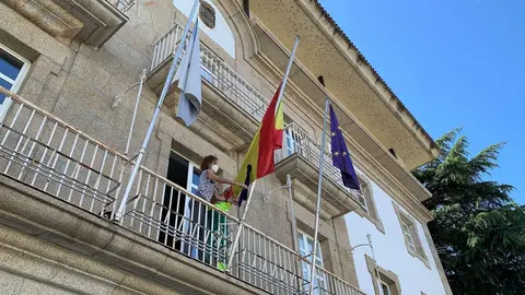 Rosario Rodr&iacute;guez, la segunda teniente de alcalde, coloca el cresp&oacute;n negro en la bandera de Espa&ntilde;a. | FOTO: Mar&iacute;a D.