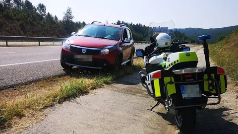 El veh&iacute;culo interceptado, con la motocicleta de uno de los agentes que le dieron el alto.