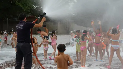 Manuel Silva, adecentando con agua a los peque&ntilde;os, despu&eacute;s de haberlos embadurnado con espuma. | FOTO: Xos&eacute; Lois Colmenero.