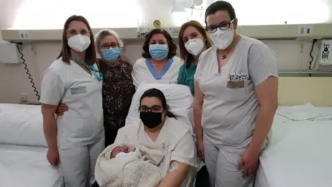 Madre e hija con parte del equipo m&eacute;dico que asisti&oacute; al parto y un familiar.