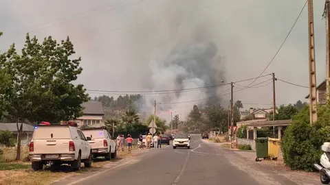 Efectivos antiincendios e veci&ntilde;os vendo o avance das lapas. | FOTO:  Xos&eacute; Lois Colmenero.