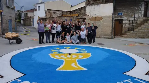 Los autores de las alfombras de San Cibrao, posando con sus obras de arte floral.