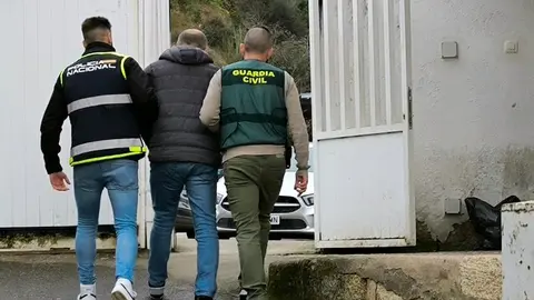 Un agente de la Polic&iacute;a Nacional y otro de la Guardia Civil, con el detenido, en el cuartel verinense. | FOTO: Guardia Civil.