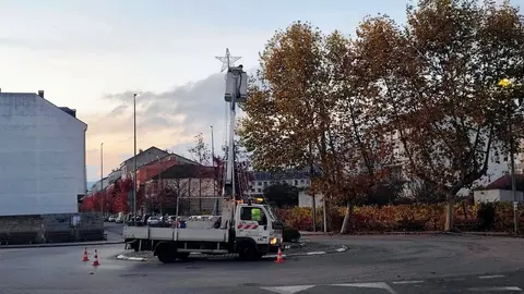 Operarios de la empresa instaladora del alumbrado navide&ntilde;o, en la rotonda de Canella Cega, con Espido e Infistela. | FOTO: Xos&eacute; Lois Colmenero.