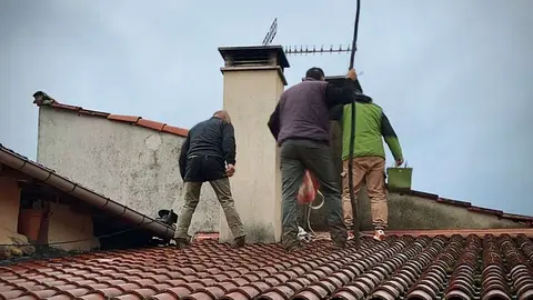 Vecinos de Vilamaior, en Ver&iacute;n, en lo alto de un tejado, colaborando en el rescate de Rayo.