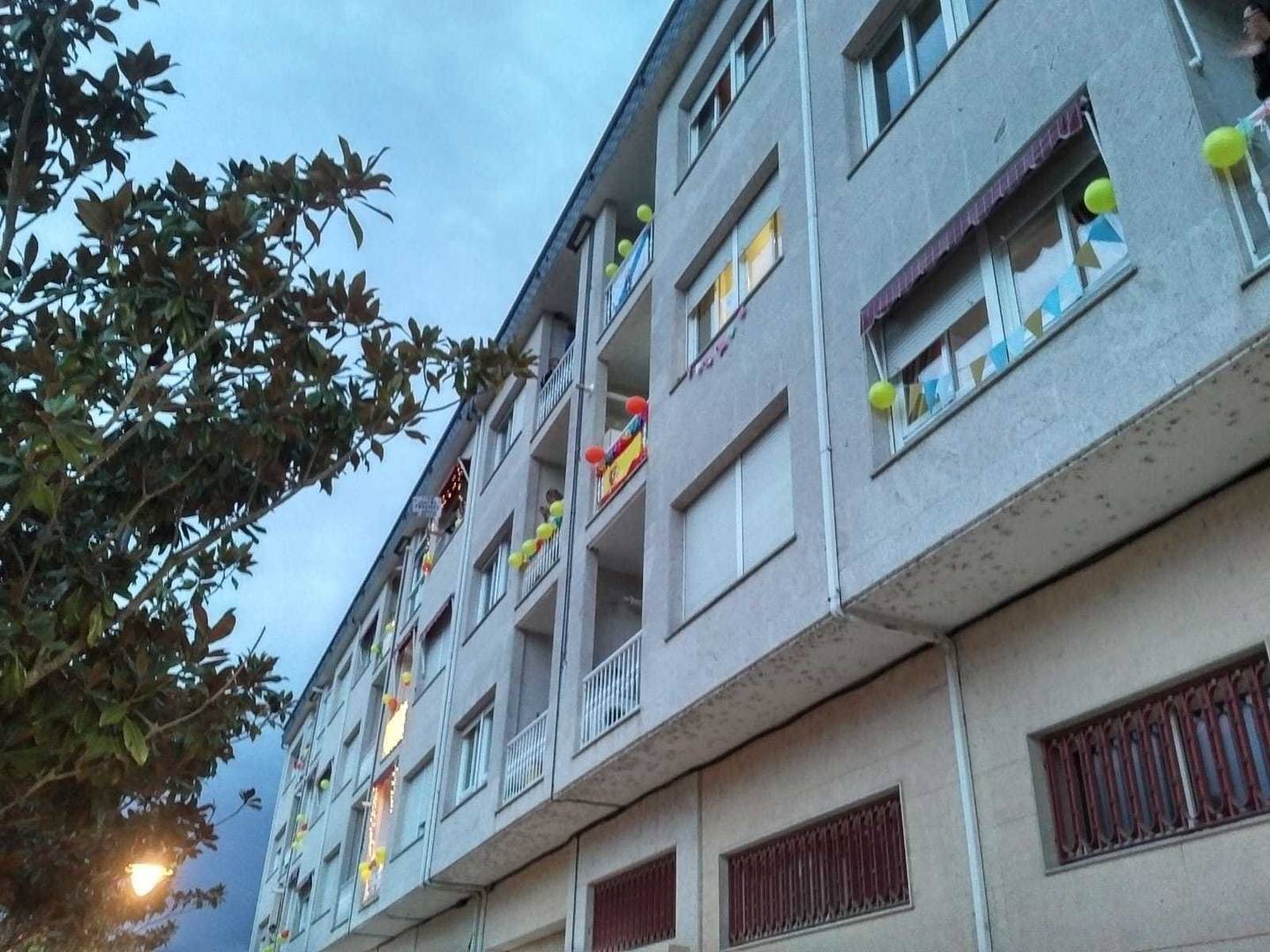 Los vecinos emplearon buena parte de la tarde en decorar sus balcones para la sesión discotequera vespertina. | FOTO: Xosé Lois Colmenero.