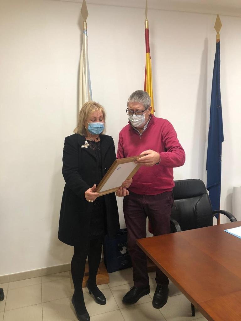 María Barreira recibe, de mans do alcalde Vicente Gómez, a placa pola que se nomea ao seu finado compañeiro Raúl Fernández, fillo predilecto de Castrelo do Val.