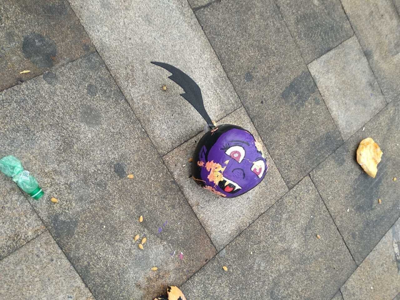 Una de las calabazas, rota y tirada en el suelo.