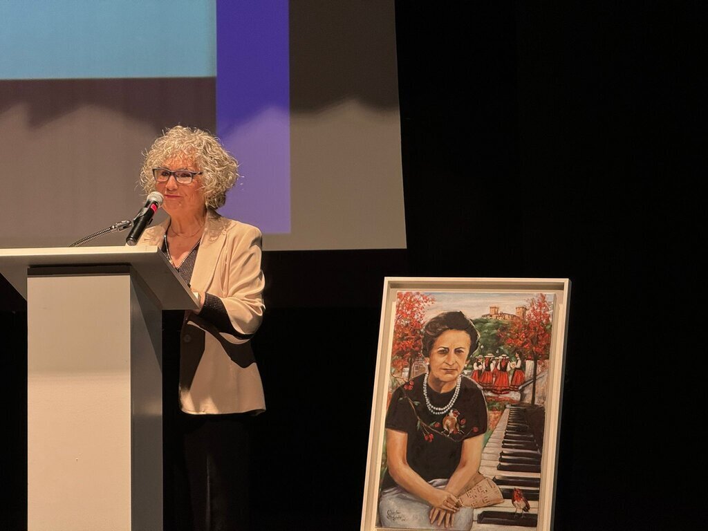 La presentadora del acto, Nora Sola, con la obra "Son do Encanto" de Marilar Salgado, en homenaje a "Doña Lolita". | FOTO: Carlos Montero.