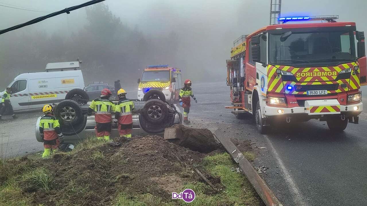 Agentes trabajando para liberar al varón atrapado en su vehículo en As Estivadas.