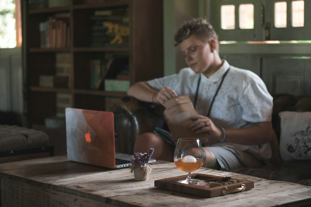 hombre sentado sofá con portátil, teletrabajo, nómadas digitales FOTO de Trinity Treft