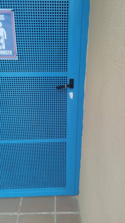 Silicona en la puerta de los baños de la piscina de Vilardevós